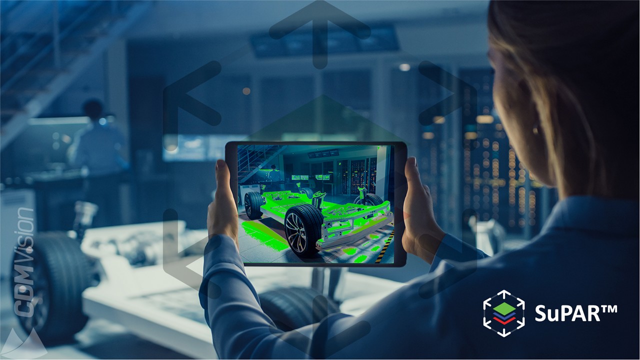 Person hält ein Tablet vor eine Fahrzeugplattform; auf dem Display liegt das grün eingefärbte CAD-Modell über dem realen Aufbau